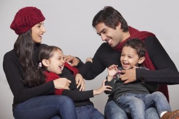 Playful family sitting over grey background 