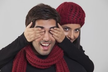 Young woman covering man’s eyes 