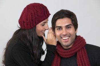 Young woman whispering in man’s ear 