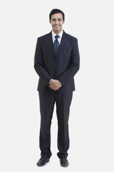 Full length portrait of young businessman in suit isolated over gray background 