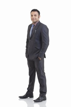 Full length portrait of mid adult businessman with hand in pocket isolated over white background 