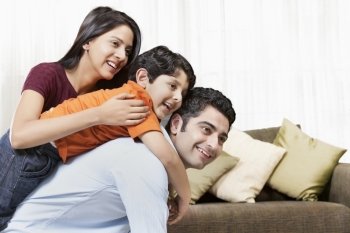 Happy Indian family of three playing at home 