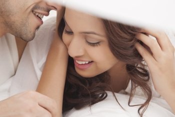 Close-up of couple romancing in bed