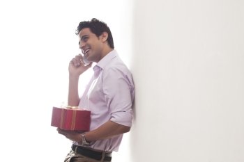 Man with a gift talking on a mobile phone