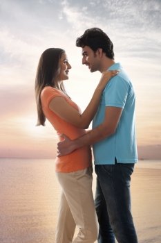 Side view of affectionate young couple embracing at beach