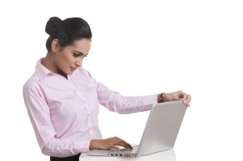 Young Indian businesswoman using laptop against white background