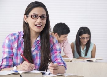 Female student with friends in background at classroom