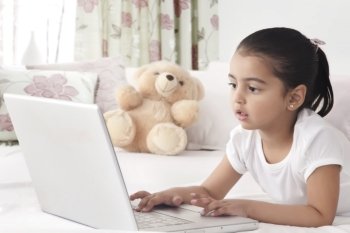 Girl using laptop in bed