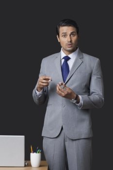 Portrait of Indian businessman holding lip balm pot in office