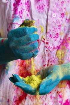 Close-up of person holding yellow powder paint during Holi festival