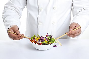 Chef with chopsticks in vegetable bowl