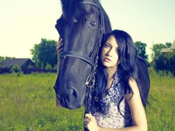 Fashionable portrait of a beautiful young woman and horse 