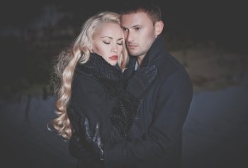 Young attractive couple in black autumn coat