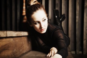 Portrait of a beautiful young woman lying on the wooden steps