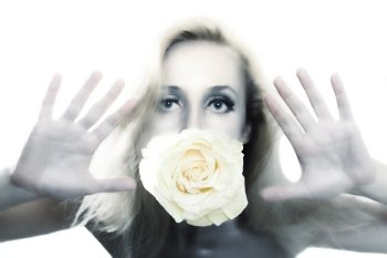 Young beautiful woman with silver make-up holding flower of white roses in his mouth