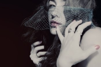 Young beautiful woman in the veil on a black background closeup