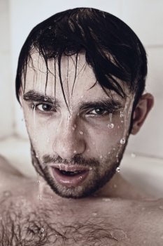 Wet face men in the shower closeup