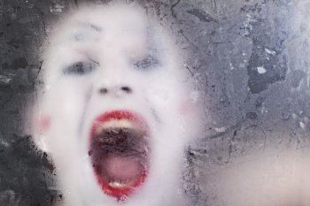 Scary face screaming mime for murky glass closeup