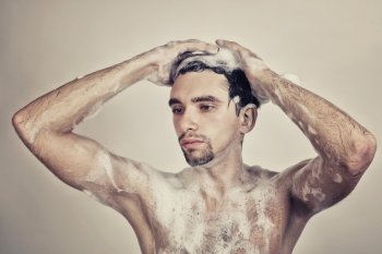 Wet naked young man in foam