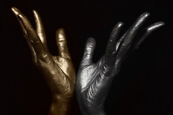 Male hands with metallic make-up on black background