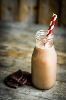 Chocolate milk in a jar on wooden background