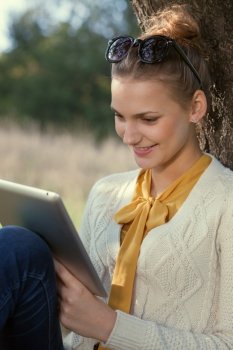 Close Up of using ipad young woman in the park. Touching touchscreen