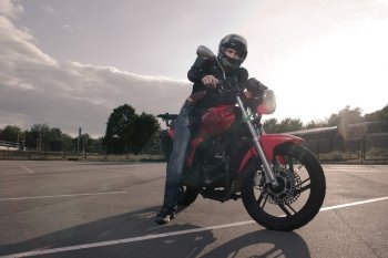 biker in helmet posing on motorbike