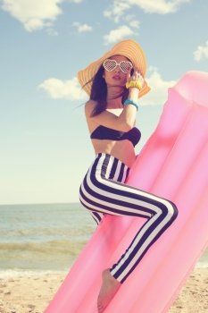 Fashionable woman in stylish swimsuit on beach