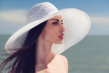 Closeup portrait of woman in big white hat