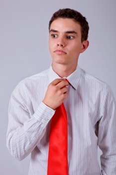 young business man pensive, adjusting his tie
