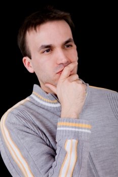young casual man thinking on black background