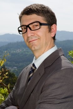 portrait of a young happy businessman with glasses, outdoors