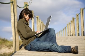 young woman working with computer at the beach
