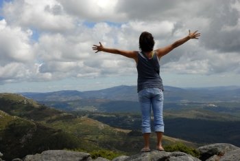woman with arms wide open in the mountain