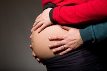 hands embrace a belly of the pregnant woman