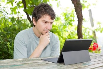 casual man working with a tablet pc, outdoor