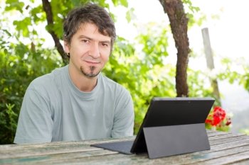 young happy man with a tablet pc, outdoor