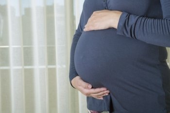 Closeup of pregnant woman at home