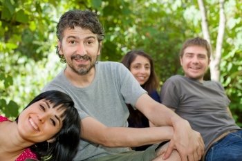 group of friends relaxing outdoors, focus on the man on the left