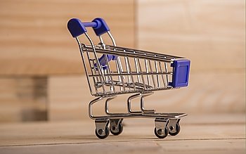 small shopping cart, studio picture on a wooden table
