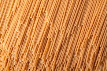 Raw spaghetti spread out from top to bottom and side to side, creating a textured background.
