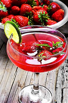 Mojito with lime and strawberry. alcohol cocktail in glass on a long stalk with strawberries and lime
