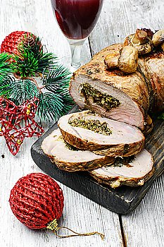 Knuckle meat for Christmas. Dish of roulade of veal stuffed with mushrooms and spices and Christmas decorations