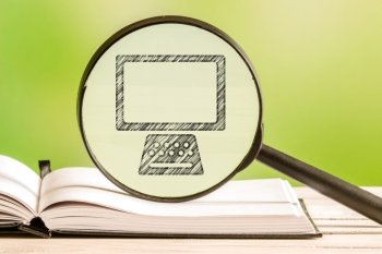 Computer search with a pencil drawing of a personal computer in a magnifying glass