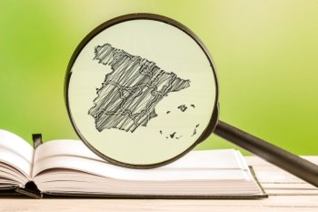 Spain with a pencil drawing of a Spain map in a magnifying glass