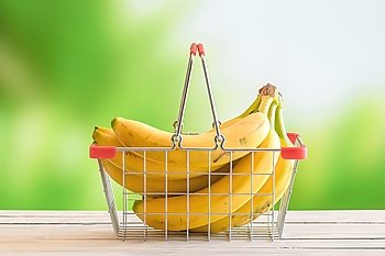 Bananas in a shopping cart on a wooden table