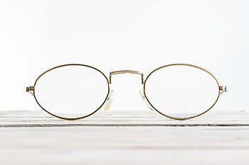 Eyeglasses on a wooden desk in bright environment