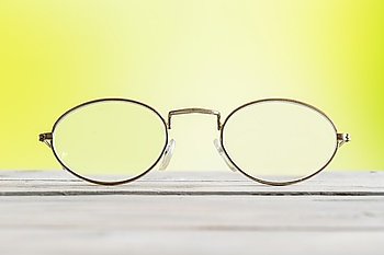 Glasses lying on a table on green background
