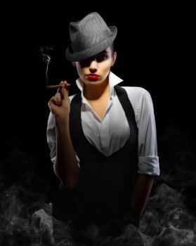 Young woman in manly style with cigar on smoky background