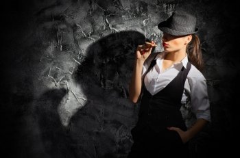 Young woman with cigar on grey wall